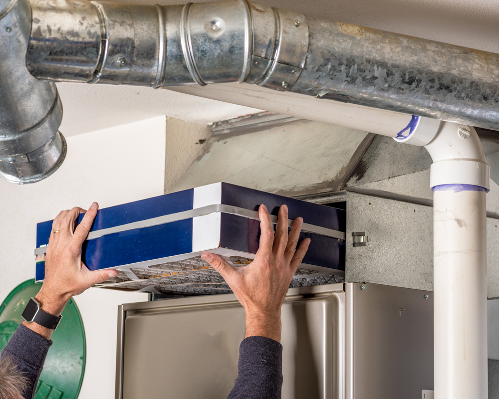 Homeowner replaces the filter in their furnace Home furnace air filter replacement